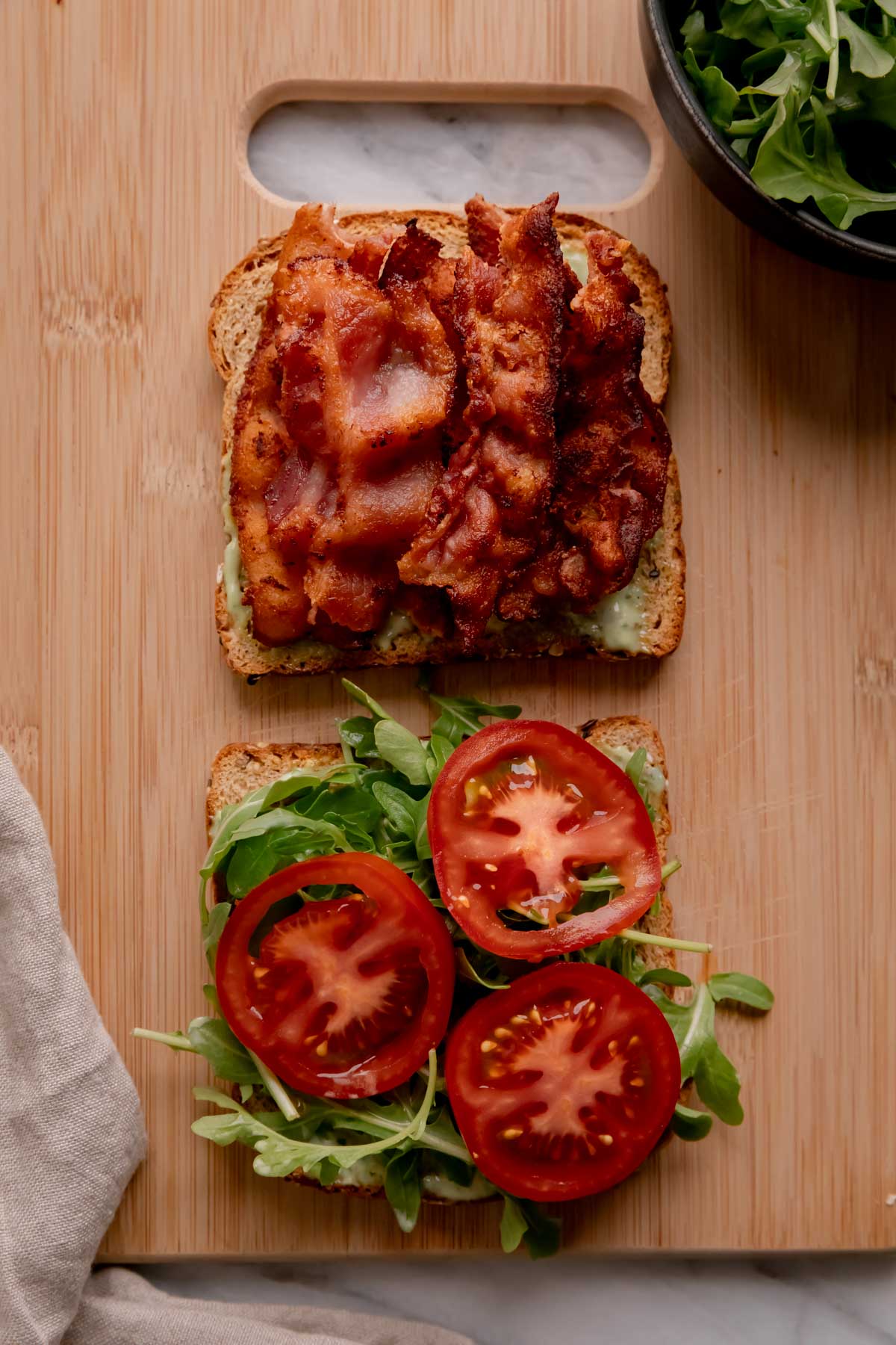 Open faced BAT sandwich on a small cutting board.