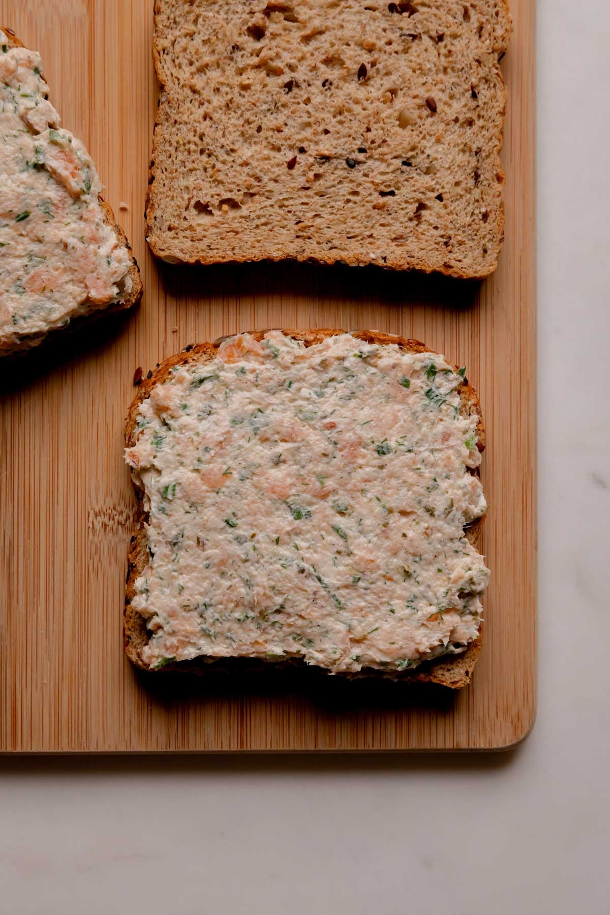 Open faced sandwiches on a cutting board.