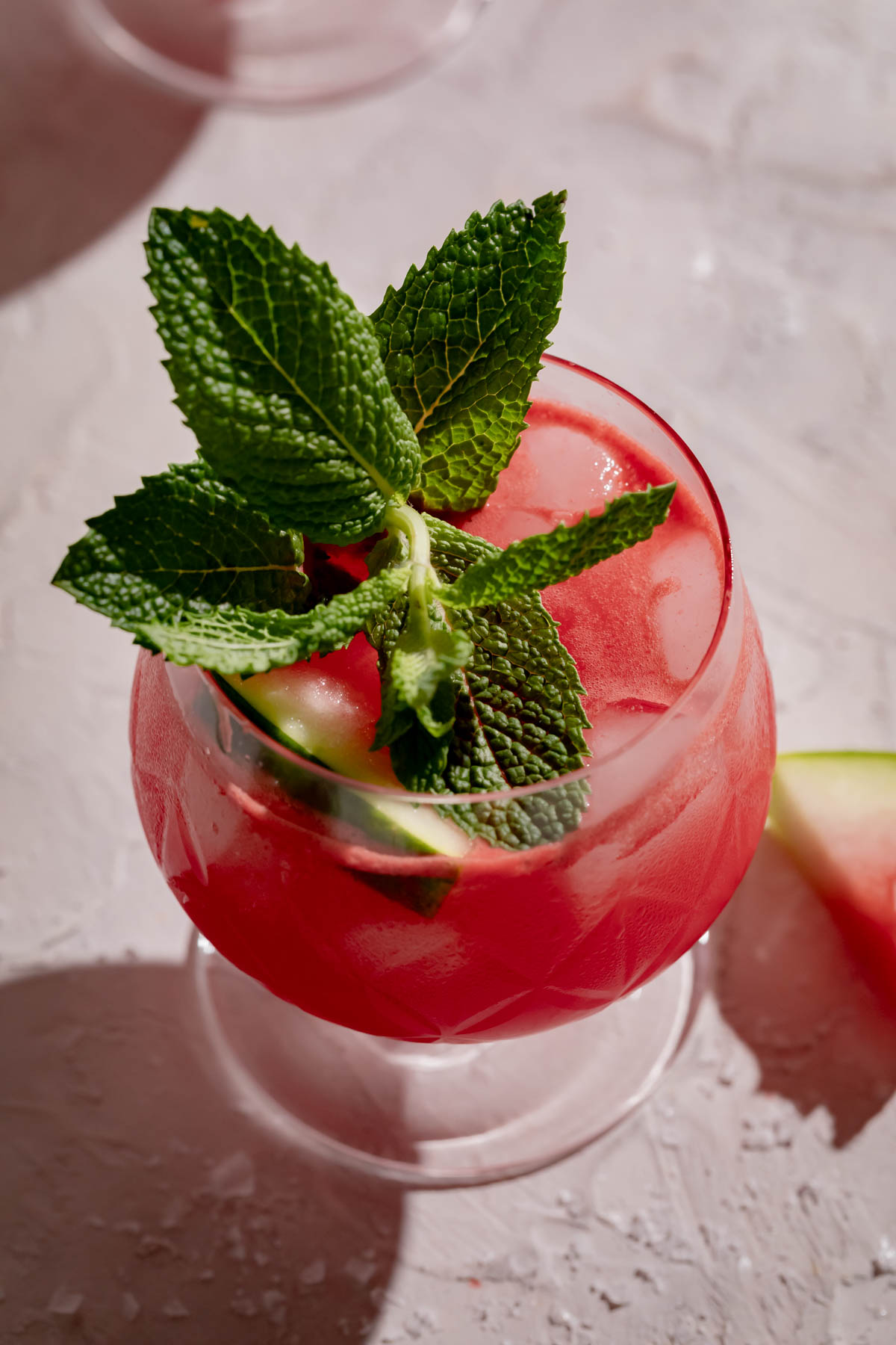 Glass of salted watermelon juice with a large sprig of mint.