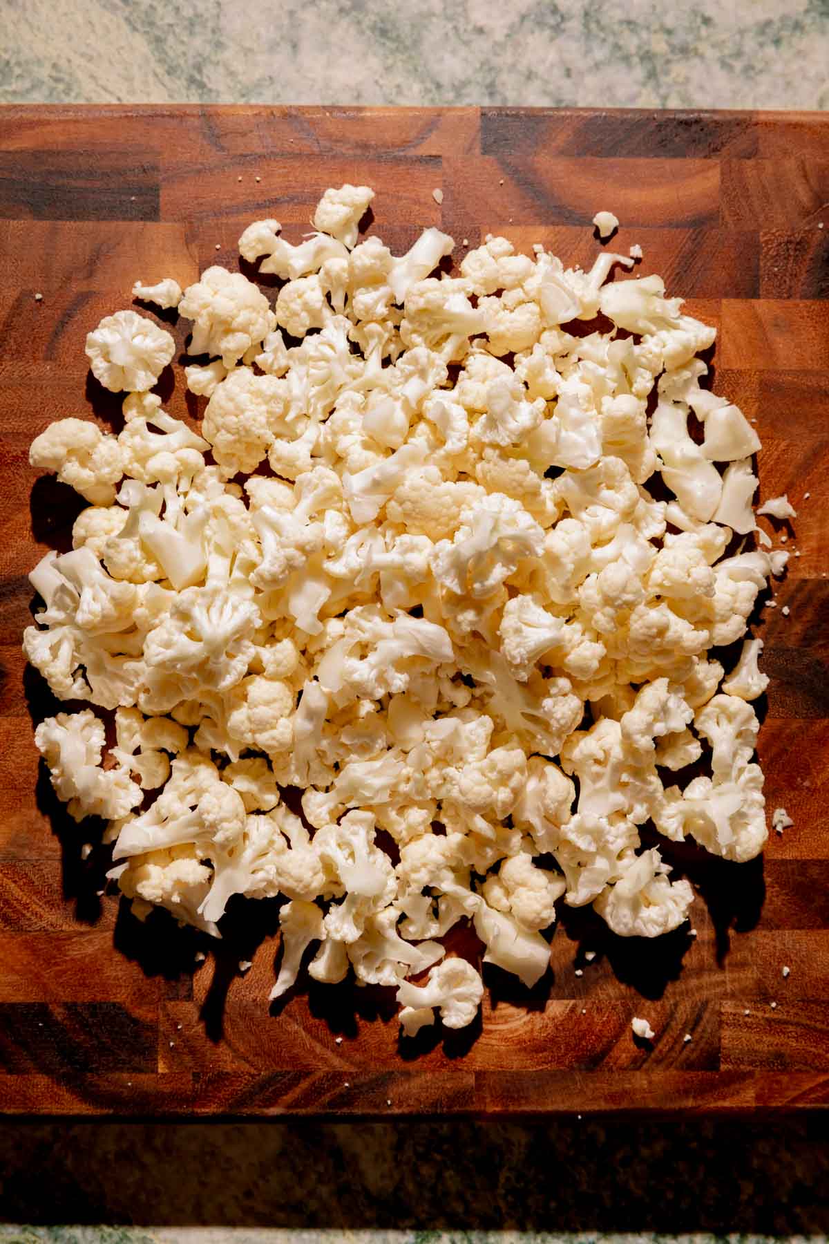 Cauliflower florets on a cutting board.