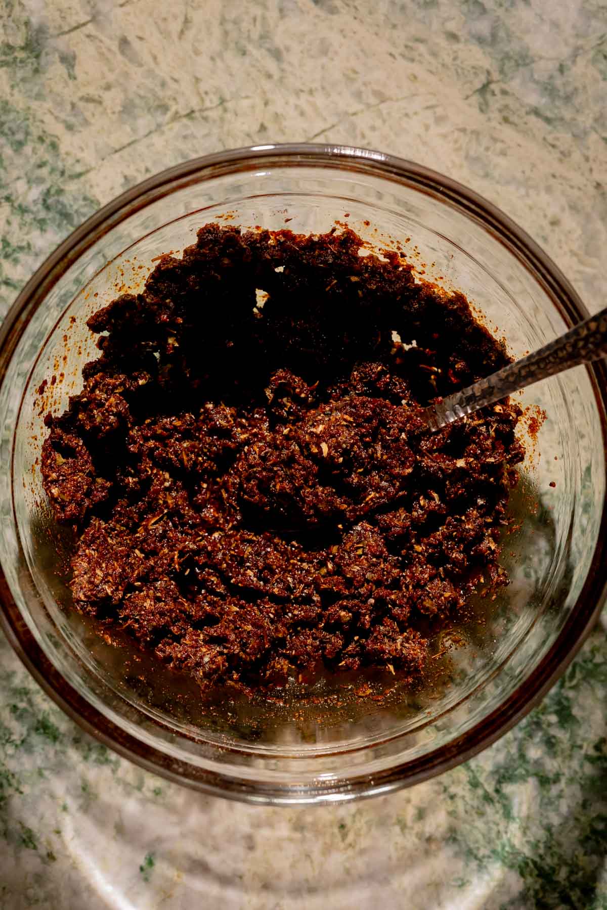Spice mixture/paste in a small bowl with a spoon.