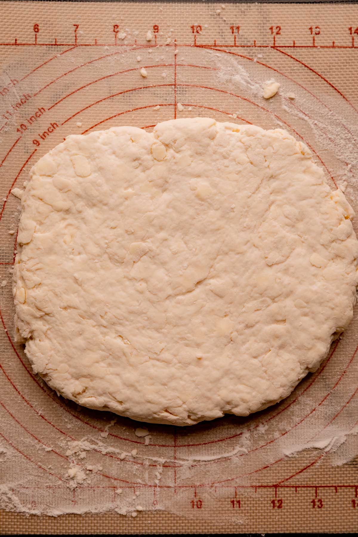 Biscuit dough flattened into a rectangle on a silpat.