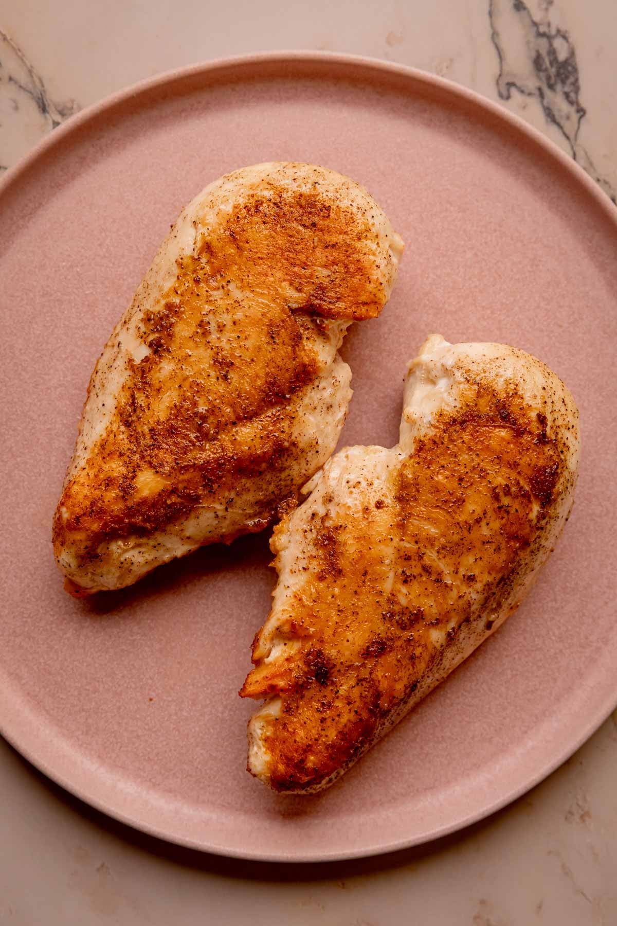 Seared chicken breasts on a plate.