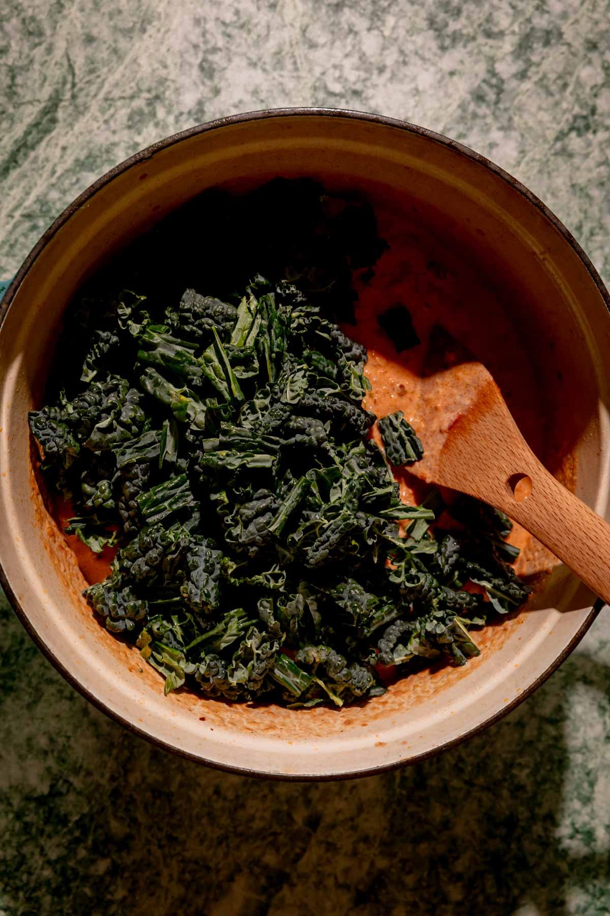 Chopped kale on top of creamy tomato sauce.