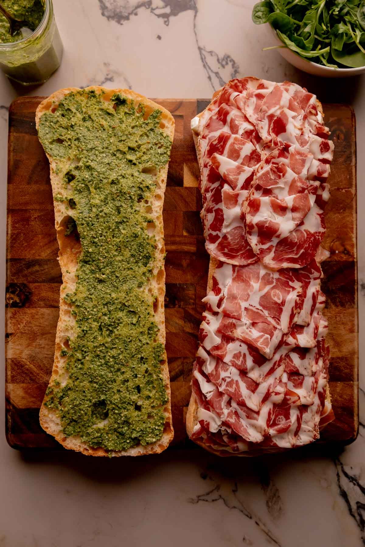 Meat layered on half of a ciabatta loaf.