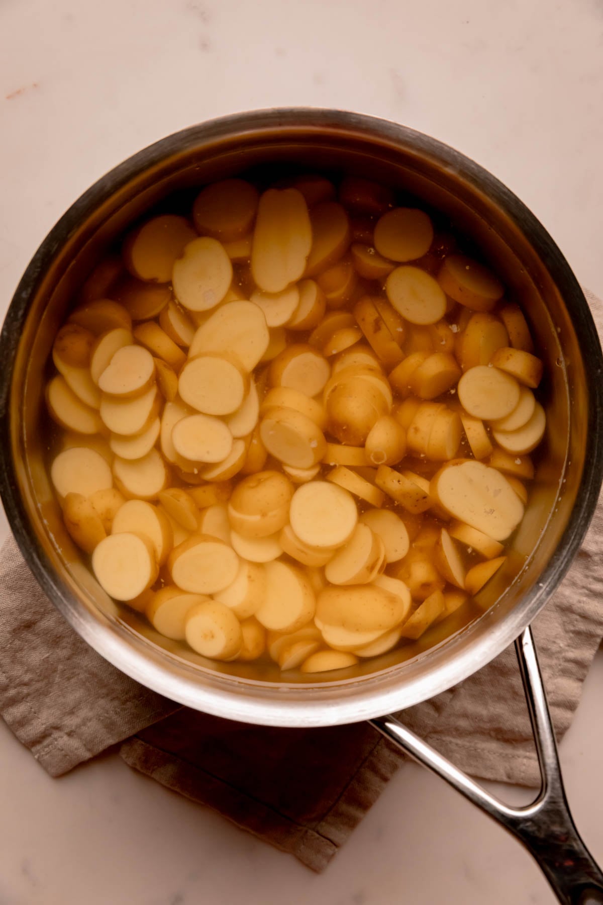 Pot of sliced potatoes in water.