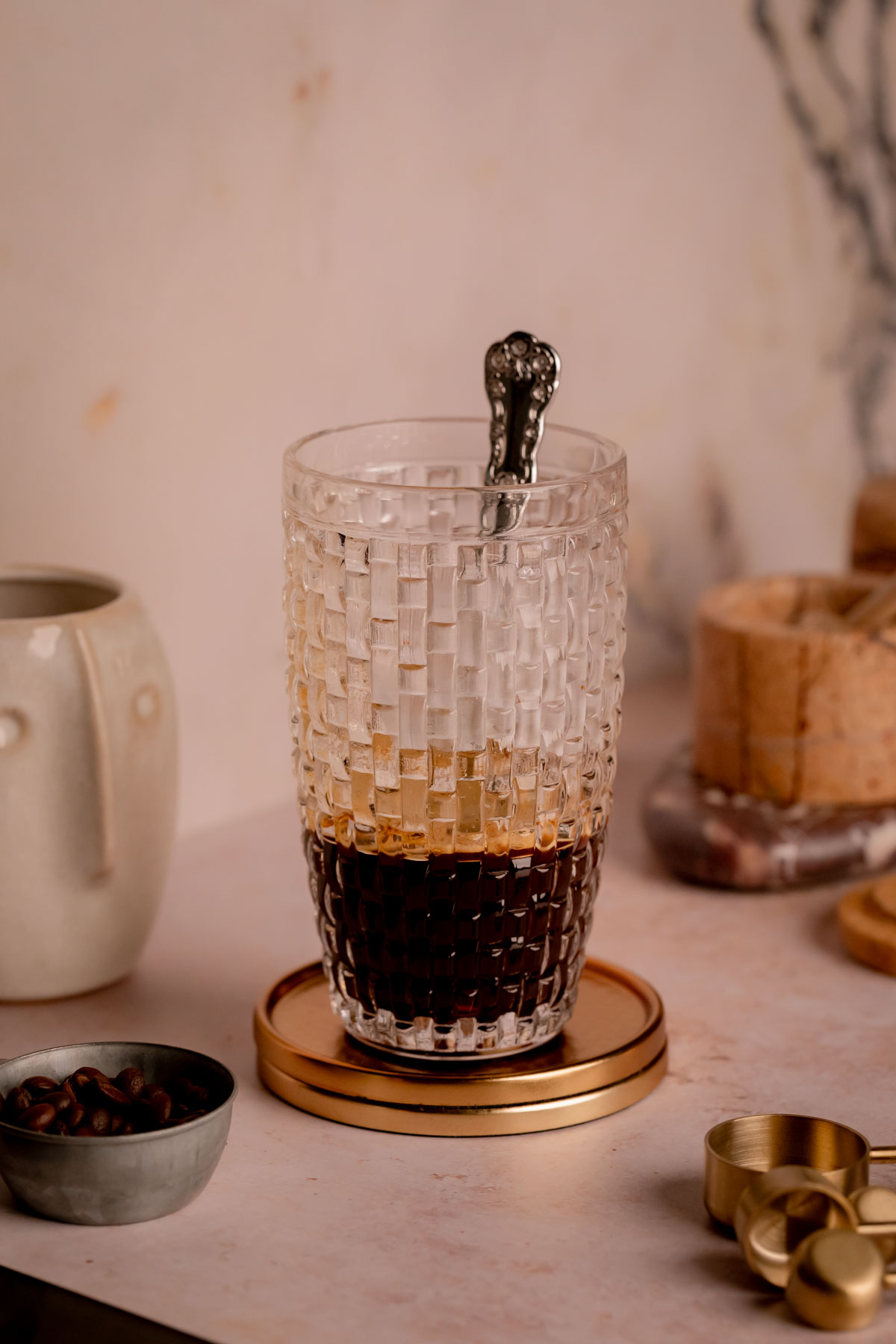 A cocktail shaker with espresso, honey, and hot water mixed together.