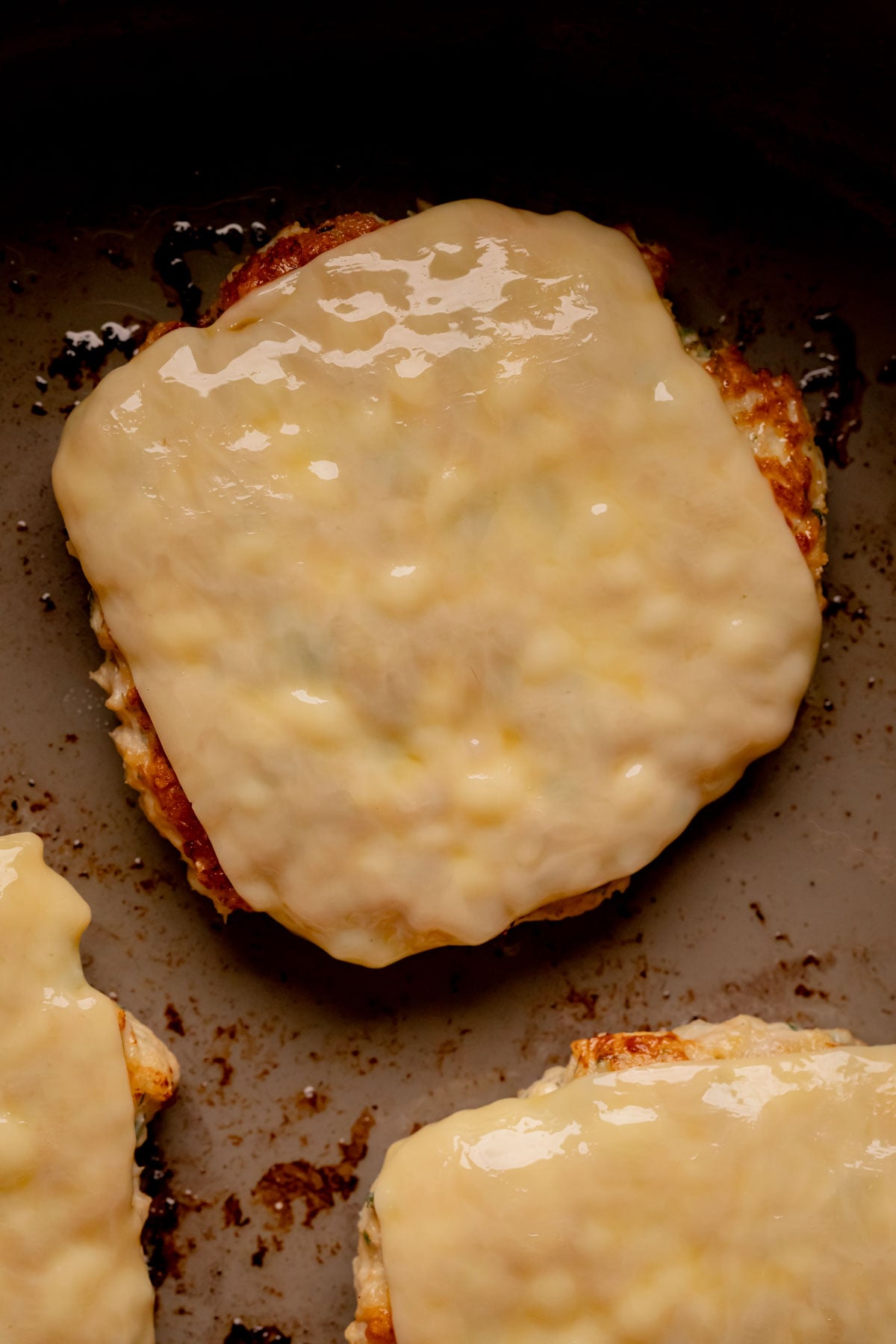A chicken patty with melted cheese on top.
