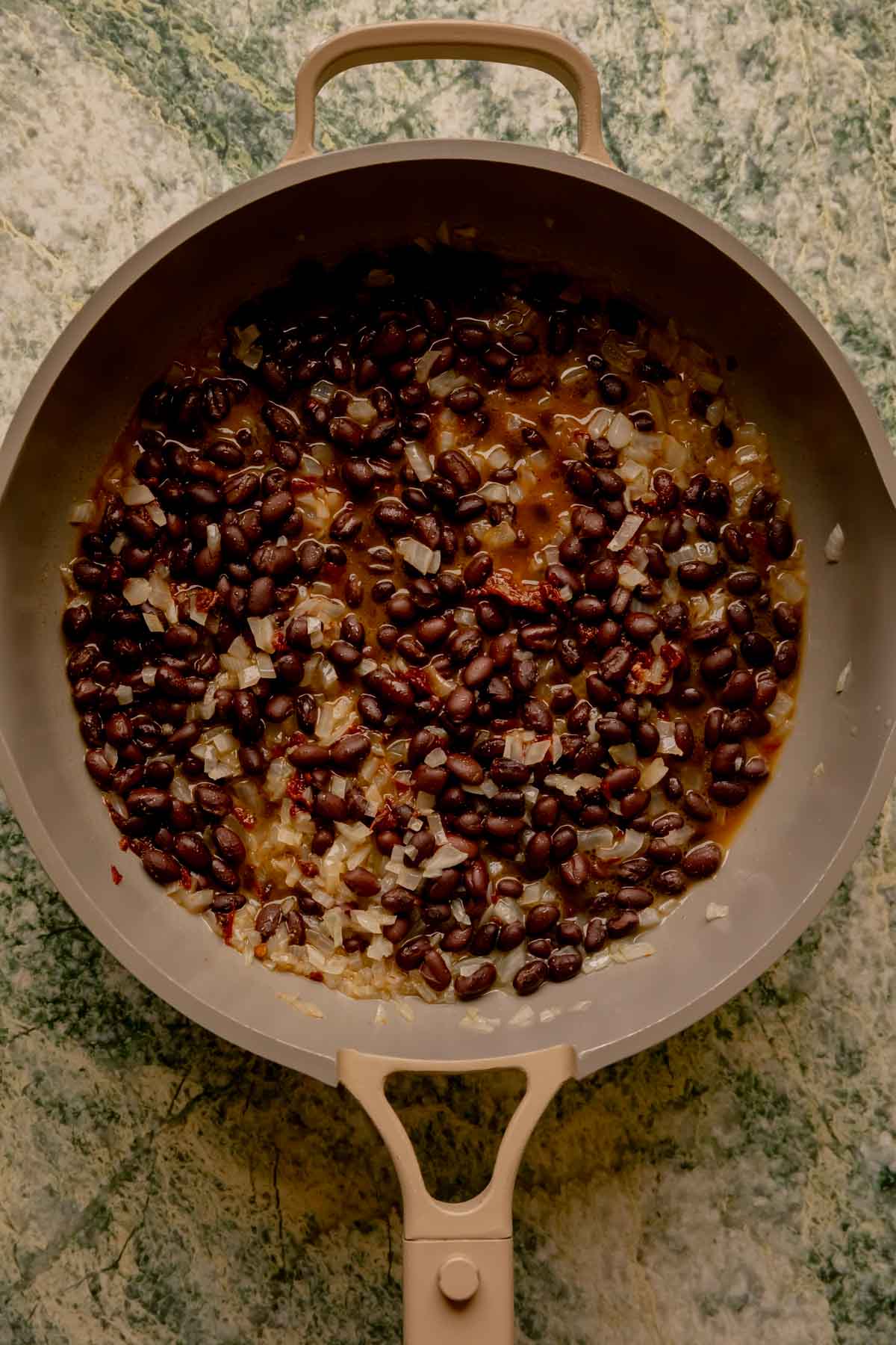 Black beans and onions in a pan.