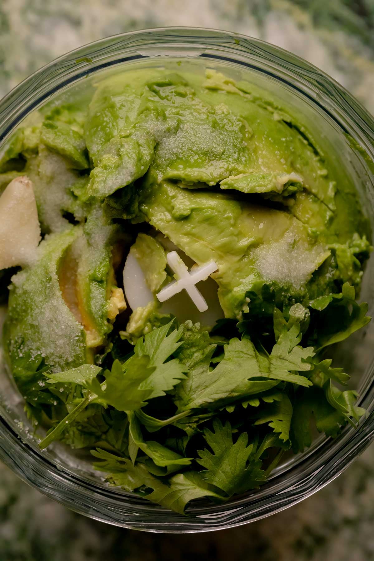 Ingredients for avocado crema in a food processor.